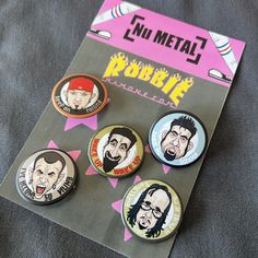 buttons with cartoon faces on them sitting on a piece of cloth