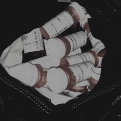 a black and white photo of several bottles in a bag with the lid open to show their contents