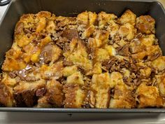 a pan filled with bread and pudding on top of a stove