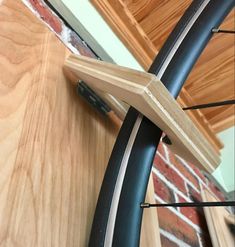 a close up of a bike tire on a wooden surface near a brick wall and door