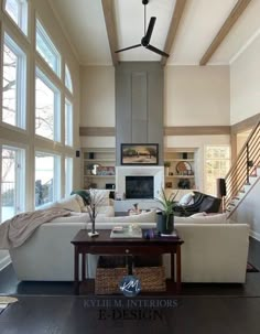 a living room filled with white furniture and large windowed windows next to a fire place