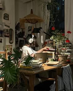 a woman sitting at a desk with headphones on, working on a laptop computer