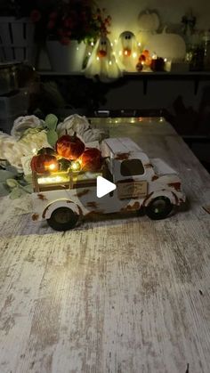 a toy truck with flowers in the back and lights on it sitting on a table