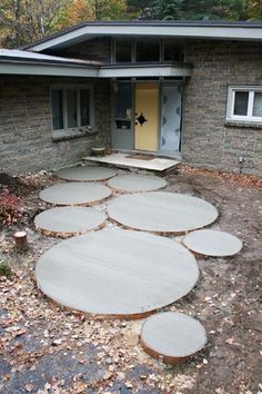 a house with stepping stones in front of it and a yellow door on the side