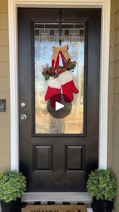 the front door is decorated for christmas with wreaths and stockings on it's side