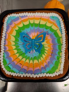 there is a cake decorated like a butterfly on top of the pan with icing