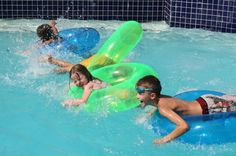 two children are playing in the pool with their floats