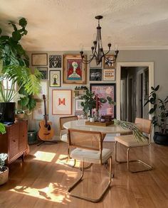 a living room filled with furniture and lots of plants on top of a hard wood floor