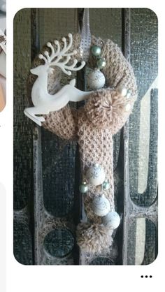 a knitted decoration hanging on the side of a door with deer and ornaments around it