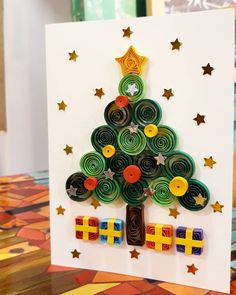 a christmas tree made out of rolled paper and magnets on top of a card