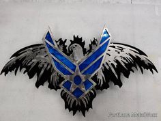 an emblem on the side of a building with blue and black wings flying around it