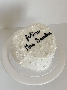 a white cake with black writing on it