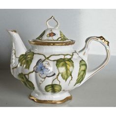 a tea pot with a butterfly on it