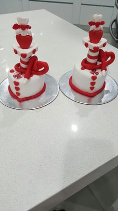 two cakes with red and white frosting on top of each other sitting on a counter