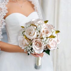 a bridal holding a bouquet of roses and baby's breath