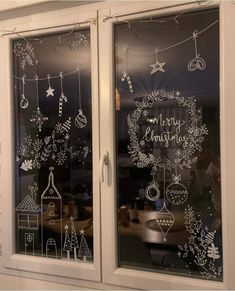 two windows with christmas decorations drawn on them