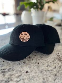 "- Personalized gift for mom and grandma -  This hat features the name of your choice in script font and child/children/grandchild/grandchildren names will be in print.  The leather patch on the hat is round and measures 1.63\".  The design has been laser engraved into the leather material.   Each hat is made of 100% cotton and there are 4 color choices available- black, dark gray, white and tan.  There is an adjustable strap on the back of the hat for appropriate sizing. Mom gift, Mom hat, Mothers day gift, Mothers gift, Personalized gifts for mom, Personalized gift for grandma, Personalized gift for her" Mom With Kids, Mom Hat, Personalized Grandma Gifts, Mom Hats, Hat Types, Personalized Grandma, Hat Ideas, Personalized Gifts For Mom, Gift For Grandma