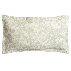 a white and green pillow with a floral pattern