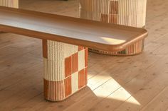 a wooden bench sitting on top of a hard wood floor next to two wicker baskets