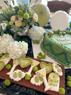 a table topped with green and white decorated cakes