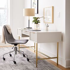 an office with a desk, chair and lamp in the corner on top of carpeted floor