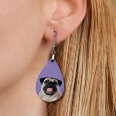 a close up of a person wearing a pair of earrings with a dog on it