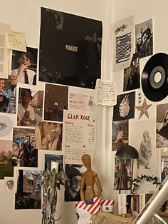 a cluttered room with many pictures on the wall and a guitar in the foreground