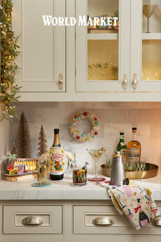 a kitchen with white cabinets and christmas decorations on the counter top in front of it