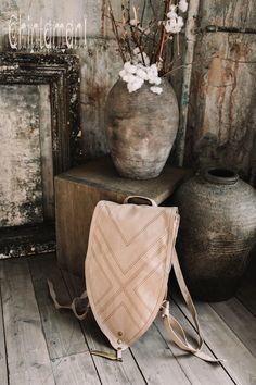 "⫸ We ship by EXPRESS EMS now for fast & safe delivery! Our unique shield shaped unisex boho backpack is a gorgeous artifact to carry your everyday necessities around. It is made out of double layered strong cotton canvas and decorated with huge solid brass feather pendant, as well, as geometric tribal protective stitching. The straps are regulated with beautiful brass rings and can be adjusted in length for your convenience. There are two secure small zipped pockets for valuables and gadget Bohemian Leather Backpack For Everyday, Bohemian Leather Backpack For Everyday Use, Bohemian Leather Backpack With Adjustable Strap, Everyday Bohemian Leather Backpack, Bohemian Beige Backpack, Bohemian Backpack For Everyday Use, Bohemian Satchel Backpack For Everyday Use, Bohemian Leather Backpack For Daily Use, Navajo Pattern