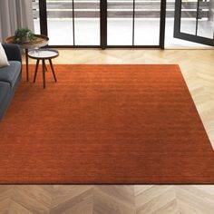 a living room with an orange rug on the floor