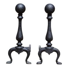 pair of black iron candlesticks with ball finial and foot rests on white background