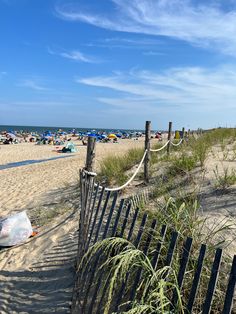 the beach is crowded with people and umbrellas on a sunny day at the ocean