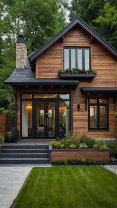 a house that is in the middle of some trees and grass with plants on it