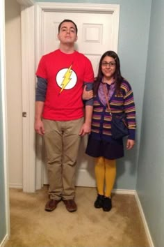 a man and woman standing in front of a door with the flash symbol on it