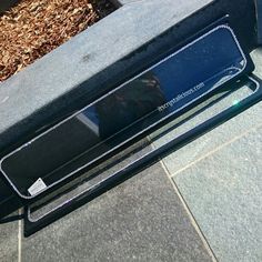 a black speaker sitting on top of a sidewalk