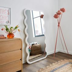 a mirror sitting on top of a wooden dresser