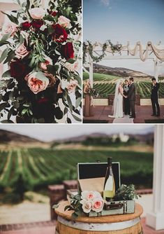 a couple standing next to each other in front of a bunch of flowers and wine bottles