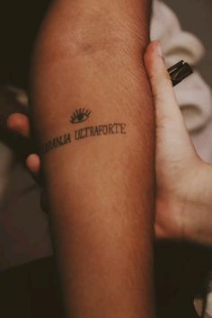 a person with a tattoo on their arm that reads virginia ultraforte and is holding the other arm