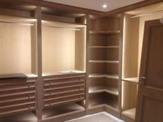 an empty walk in closet with drawers and shelves