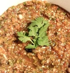 a close up of a bowl of food with some cilantro on top of it