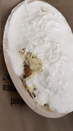 a bowl filled with noodles and sauce on top of a table