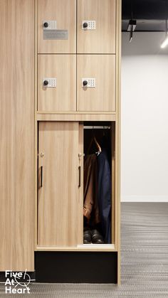 an open wooden cabinet with shoes hanging on it