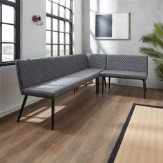 a living room with wood flooring and two gray couches next to a large window