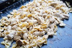 pasta with meat and cheese is being prepared on a baking sheet in the oven for cooking