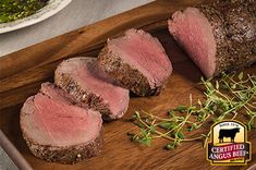 sliced beef on a cutting board with herbs