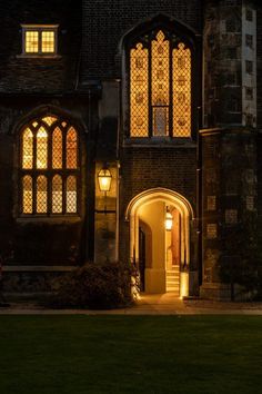 the front entrance to an old building lit up at night with lights shining on it