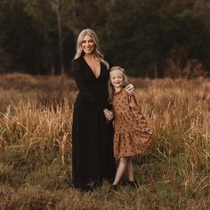 a mother and daughter posing for a photo in a field