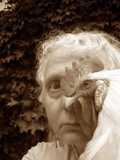 an old woman holding a chicken up to her face