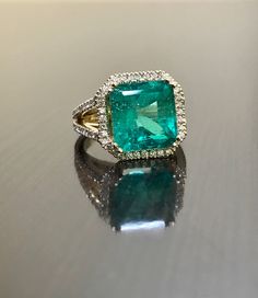 DeKara Designs Collection Metal- 18K Yellow Gold, .583. Stones- 1 Emerald Cut Green Colombian Emerald 7.12 Carats, 10.9 x 11.1 MM. 92 Round Diamonds G Color VS2 Clarity, 1.00 Carats. Art Deco Inspired Beautifully Cut and Colored Colombian Green Emerald Halo Diamond Engagement Ring Made in 18K Yellow Gold. . The pictures do not capture the true beauty, brilliance, and color of this Emerald ring. The Emerald is as square as possible for the best possible proportions. The emerald is surrounded by 3 Luxury Green Emerald Halo Ring, Dazzling Yellow Gold Rings, Luxury Diamond Ring With Emerald Accent Stones, Luxury Gold Emerald Ring For Wedding, Luxury 14k Gold Emerald Wedding Ring, Exquisite Yellow Gold Emerald Ring, Formal Yellow Gold Emerald-cut Halo Ring, Yellow Gold Emerald Cut Halo Ring For Formal Events, Yellow Gold Emerald Cut Halo Ring For Formal Occasions