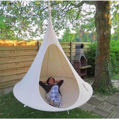 a man is laying in a hanging tent